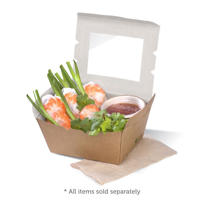 A BioBoard Lunch Box containing shrimp spring rolls, dipping sauce, green onions, and cilantro, placed on a napkin.