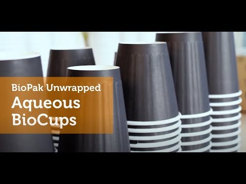 Stacks of dark-colored paper cups, including the Black Single Wall BioCup, are shown next to a text overlay that reads, "BioPak Unwrapped Aqueous BioCups.